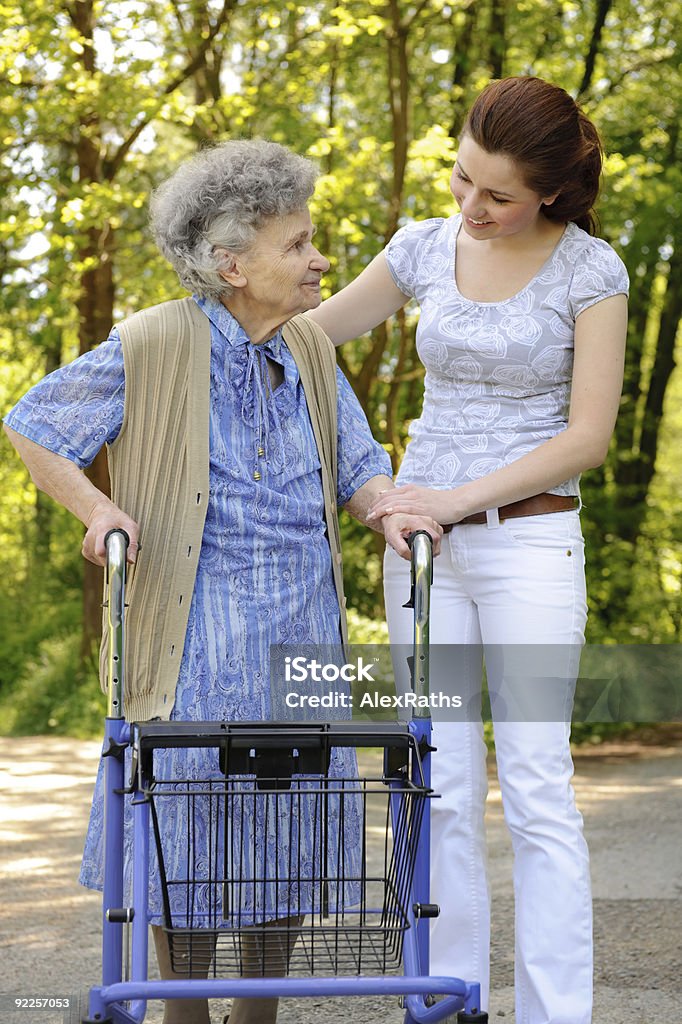 Senior Donna cammina - Foto stock royalty-free di Accudire