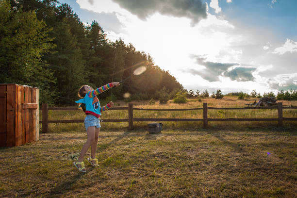 Young cute girl playing badminton at summer day sunset