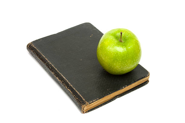 Book and green apple. White background stock photo