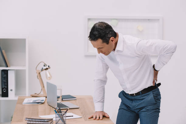 istock mature businessman with painful backache at office 922578390