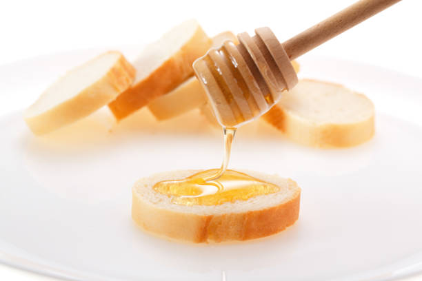 Honey is applied to the surface of bread. Isolated on a white background.