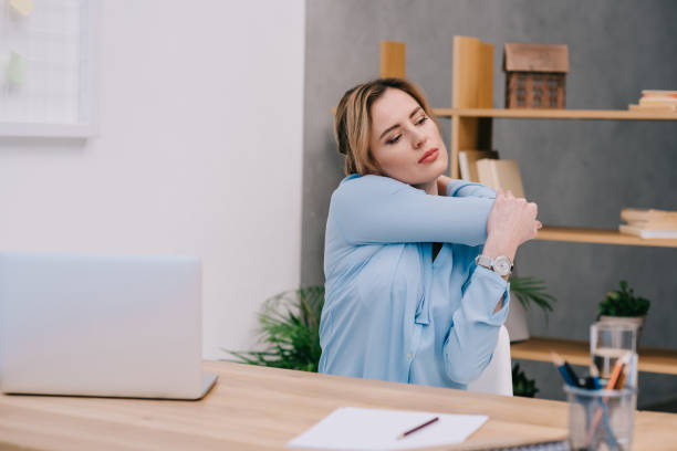 istock attractive businesswoman stretching shoulders at workplace in office 922579434