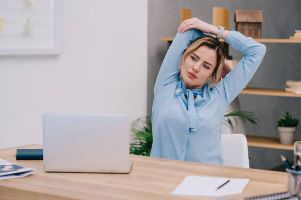 istock businesswoman stretching shoulders at workplace in office 922579514