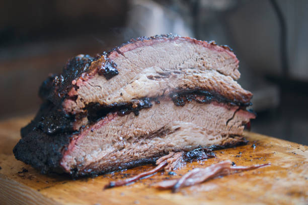 Two large pieces of smoked brisket meat on a wooden board Two large pieces of smoked brisket meat on a wooden board, concept of cooking and Haute cuisine brisket photos stock pictures, royalty-free photos & images