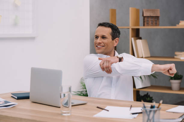 istock happy mature businessman warming up his shoulder while working at office 922579996