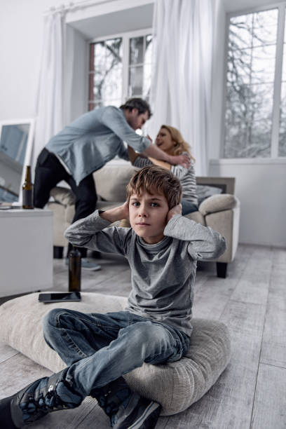 istock Sensitive boy closing his ears while his parents loudly quarreling 922580332