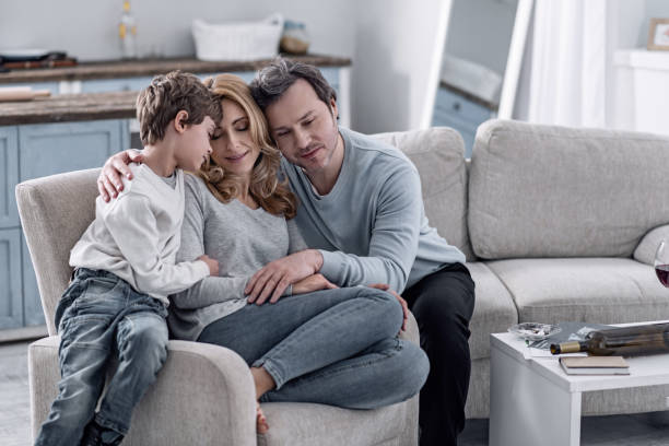 istock Peaceful man hugging his kind wife and son and feeling glad 922586358