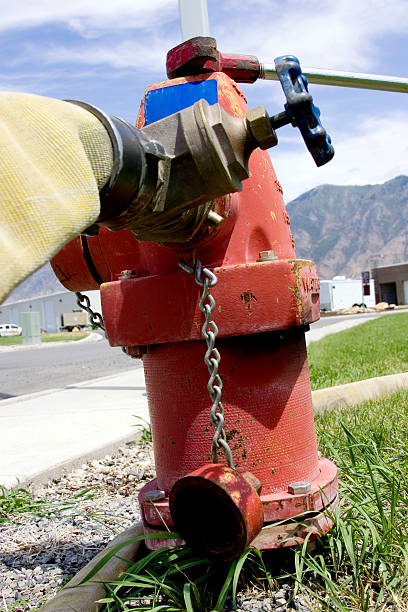 пожарный гидрант hooked и готов для обслуживания. - pipe installing water pipe threaded стоковые фото и изображения