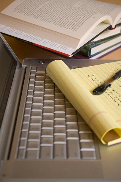 istock Laptop computer with yellow pad, pen, and books - Vertical 92259120