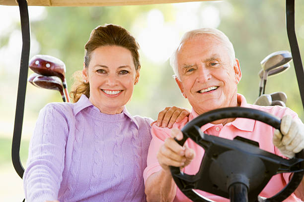 casal desfrutar de um jogo de golfe - golf course golf people sitting - fotografias e filmes do acervo