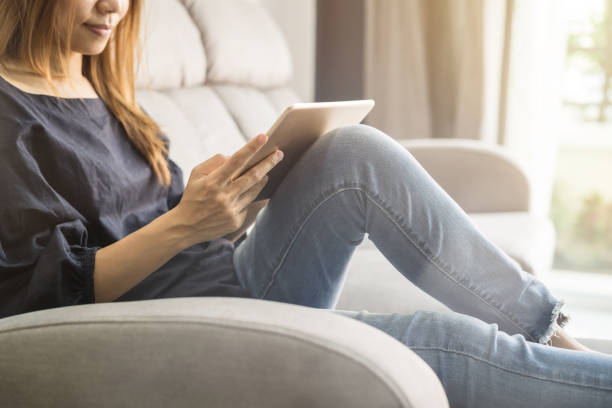 istock Young woman using tablet on sofa at home 922607288