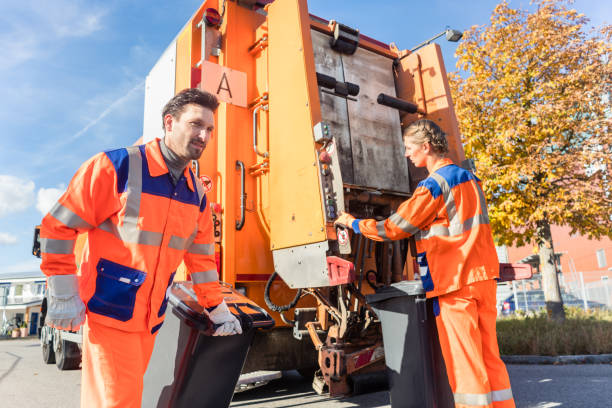 Waste collector gripping handle of garbage truck stock photo