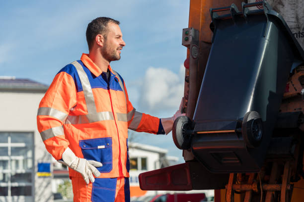 istock Garbage collection worker putting bin into waste truck 922611698