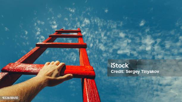 Development Attainment Motivation Career Growth Concept Mans Hand Reaching For Red Ladder Leading To A Blue Sky Stock Photo - Download Image Now