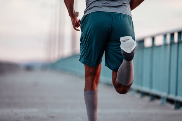 Running towards his goals Cropped image of a man running on the bridge running shorts stock pictures, royalty-free photos & images