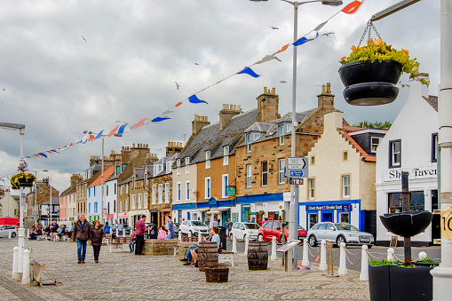 Tourists strolling on the promenade of Anstruther, a small town in the East Neuk coast of Fife, Scotland. Founded as a fishing village, Anstruther has became a well known tourist destination, being situated on the Fife Coastal Path.