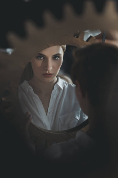 istock beautiful young woman looking at camera through mirror reflection 922623584