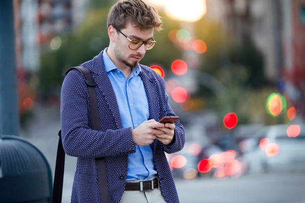 istock Handsome young businessman using his mobile phone in the street. 922623624