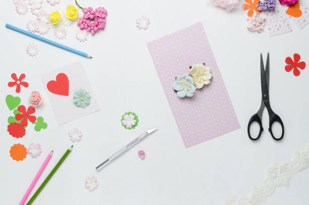 istock Paper flowers, scissors and colored pencils on white background 922623950
