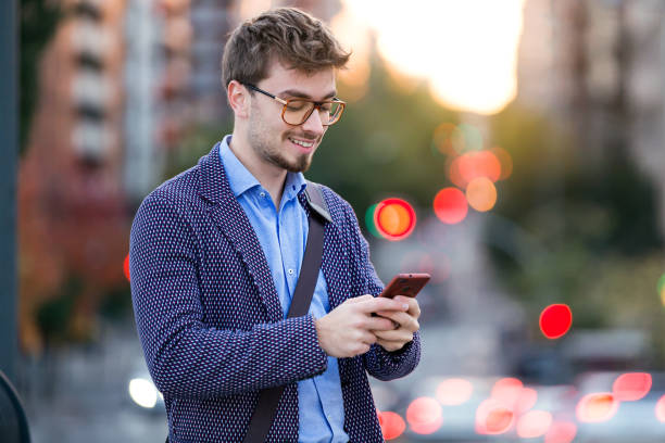 istock Handsome young businessman using his mobile phone in the street. 922624190