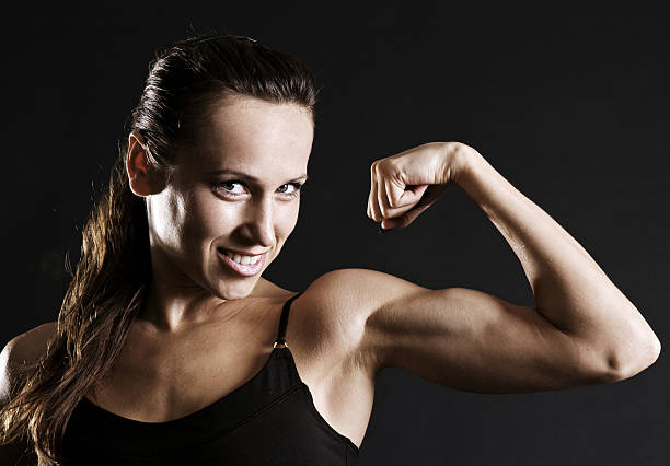istock smiley sportswoman showing her muscles 92262548