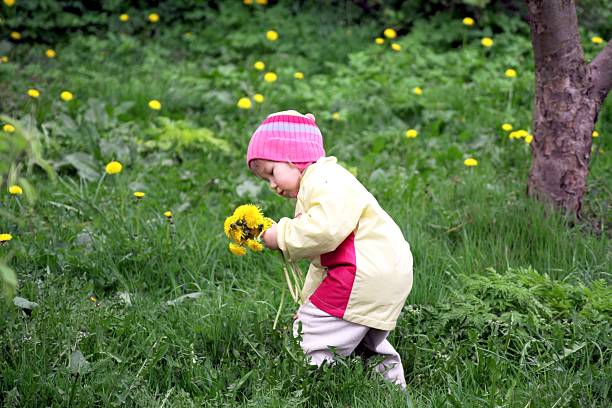 Baby boy playing and  running on lawn in spring