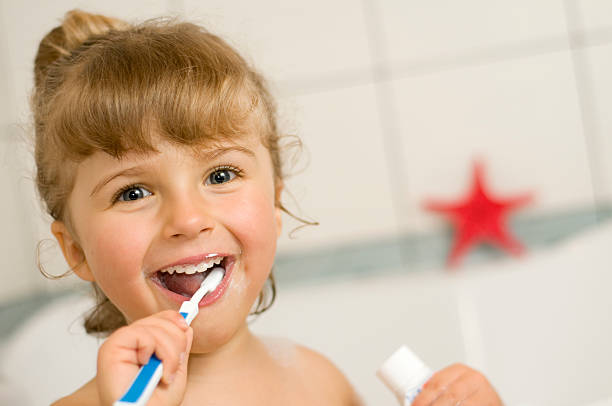 istock A smiling little girl brushing her teeth 92263580