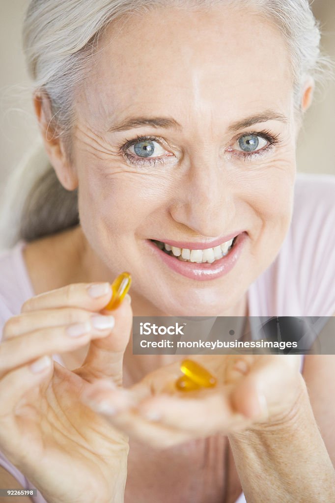 Woman 錠剤を呑む - 魚油のロイヤリティフリーストックフォト