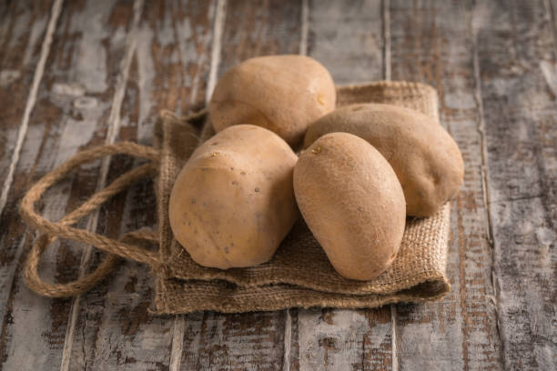 Raw Potatoes On An Old Wood Table