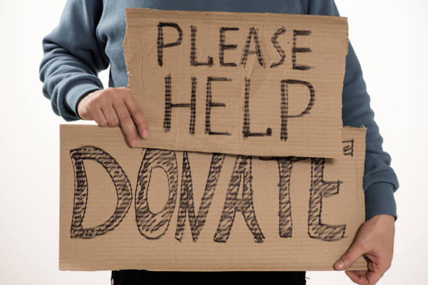 istock Homeless poor man holding carton board with word Please help, DONATE 922653072
