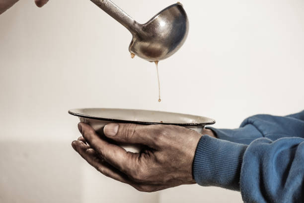 volunteers feed the homeless. free soup in a bowl of beggar. - fome imagens e fotografias de stock