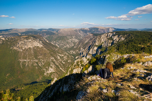 Young woman is admiring Tara Canyon from Curevac viewpoint in Durmitor National park in Montenegro