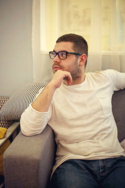istock Handsome young man at home sitting on the couch 922653998