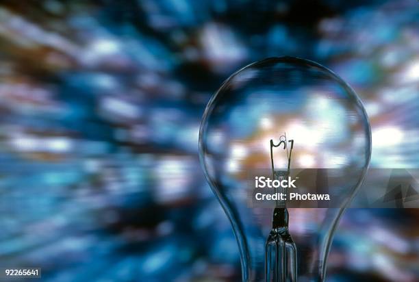 Closeup Of A Light Bulb Over A Blurred Blue Background Stock Photo - Download Image Now