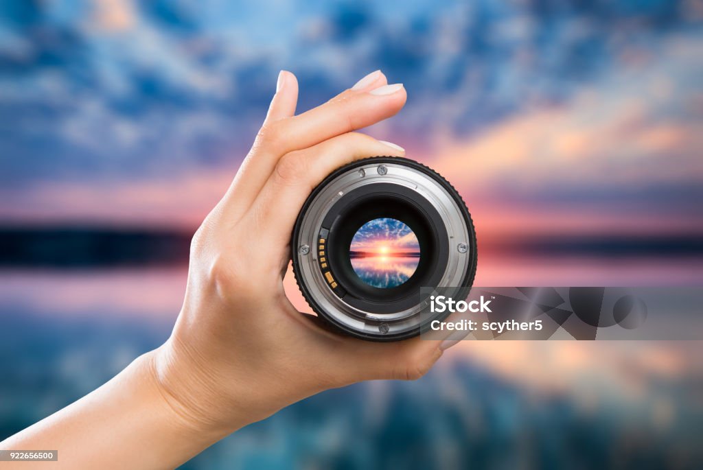 Photography camera lens concept. photography view camera photographer lens lense through video photo digital glass hand blurred focus people sun sunset sunrise cloud sky water lake concept - stock image Focus - Concept Stock Photo