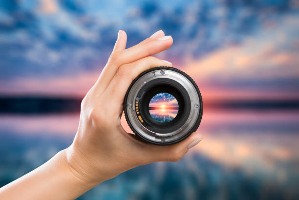 Photography camera lens concept. photography view camera photographer lens lense through video photo digital glass hand blurred focus people sun sunset sunrise cloud sky water lake concept - stock image focus stock pictures, royalty-free photos & images