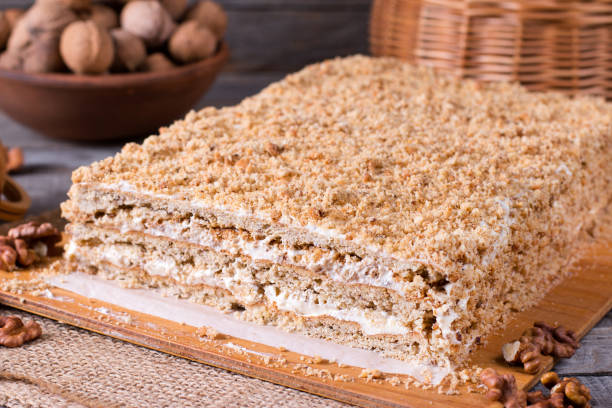 istock Delicious honey cake with sweet sour cream, and nuts on a rustic background 922657588