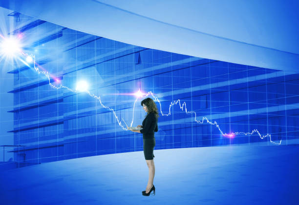 istock Businesswoman using laptop in front of bar graph chart 922657968