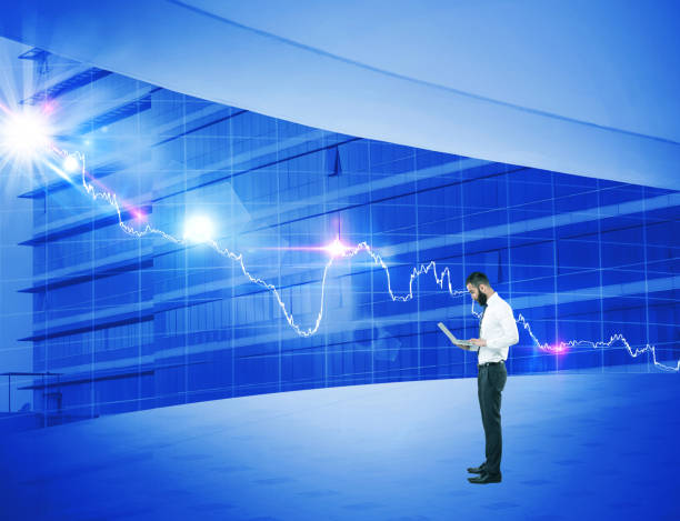 istock Businessman using laptop in front of bar graph chart 922658118