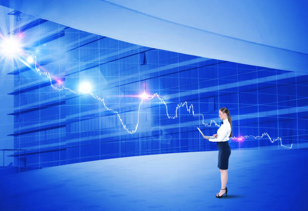 istock Businesswoman using laptop in front of bar graph chart 922658388
