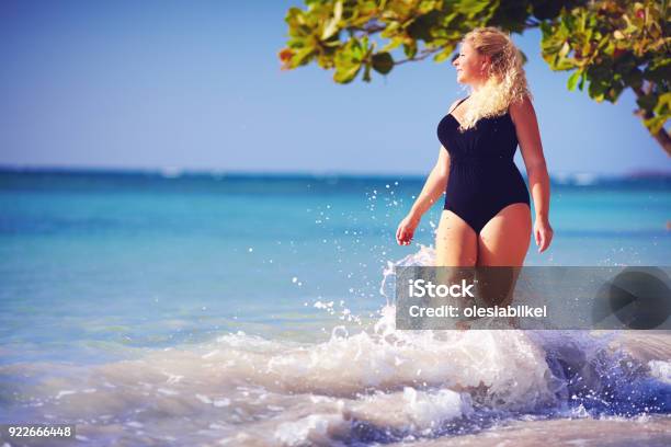 Young Plus Size Woman In Swimwear Enjoying Vacation In Water Splash On The Beach Stock Photo - Download Image Now