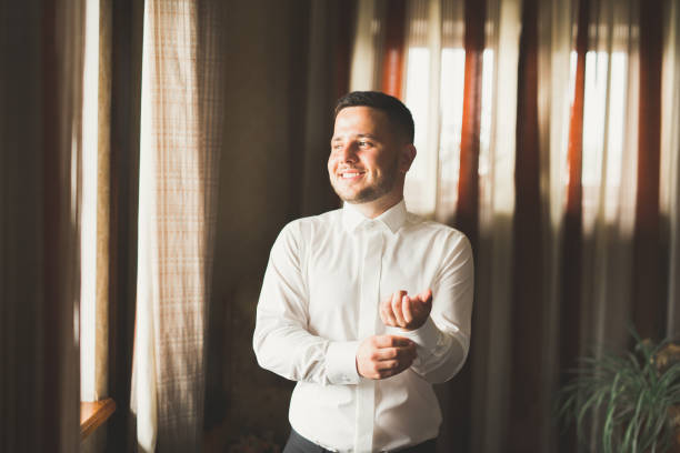 istock Grooms morning preparation. Handsome man getting dressed and preparing for the wedding 922666678