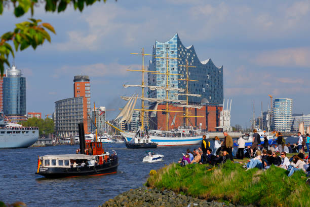 Hamburg, Germany - May 07, 2017: Hamburg harbor birthday celebration (Hafengeburtstag). One million visitors from around the world joined the world’s greatest port festival. Several ships join the parade at the end of the event - historic harbor tugboat in front. The brand new Elbphilharmonie in the background.