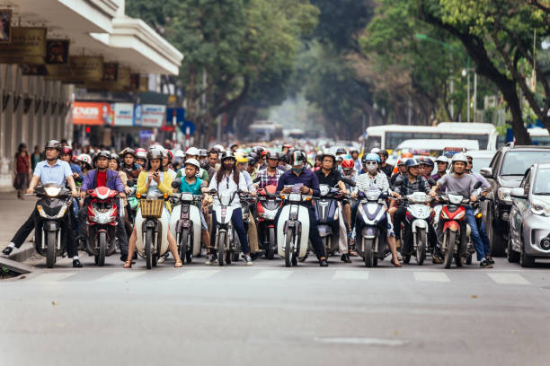 motos tem tr�áfego geleia na estrada com árvores verdes em fundo em hanói, no vietname. - vietnam asia hanoi street - fotografias e filmes do acervo