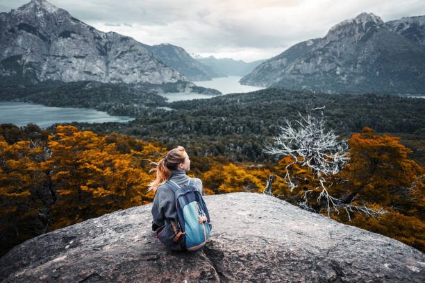 Woman hiker enjoys the valley view Woman hiker sits and enjoys valley view from viewpoint. Hiker reached top of the mountain and relaxes. Patagonia, Argentina bariloche stock pictures, royalty-free photos & images