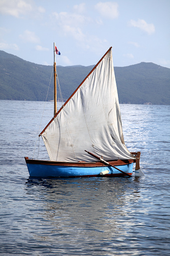 A wooden boat on blue sea in sunny day.