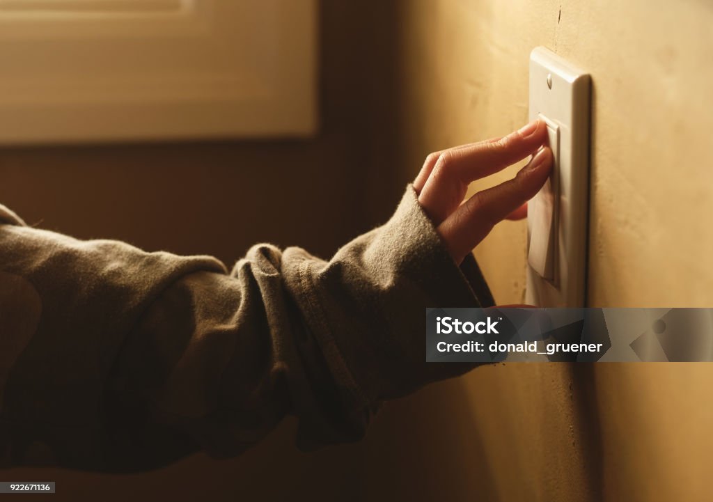 Turning On The Lights A girl operating a light switch Turning On Or Off Stock Photo