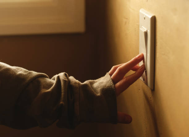 Turning On The Lights A girl operating a light switch off stock pictures, royalty-free photos & images