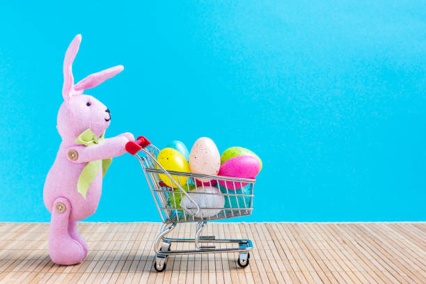 istock Easter bunny with shopping cart and colorful eggs 922671242