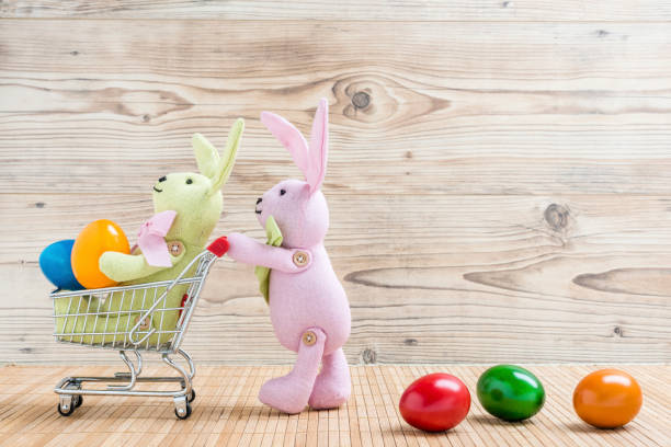 istock Two Easter bunnies with shopping carts and colorful eggs 922671250